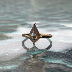 a ring with a large brown diamond on it sitting on top of some frosty ground