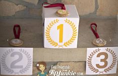 two medals are placed next to each other on top of a box with ribbon around it