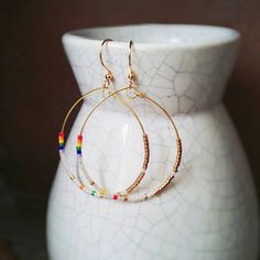 Beaded earrings on gold hoops using delicate Japanese seed beads. Mixed colours of rainbow, white and gold. Elegant and lightweight for casual wear or special occasions. ⭕Size: Width: 1 1/2" (4cm); Length: 2 1/4" (5.7cm) ⭕Hoop material: gold-plated/silver-plated steel wire ⭕ Different ear hook options available for your needs: - Nickel free gold-plated hooks - 14Kt gold-filled hooks - Silver-plated hooks - Sterling silver hooks ⭕For bigger hoops, check here: https://www.etsy.com/ca/listing/81700 White Hoop Earrings With Tiny Beads, Gold Hoop Earrings With Colorful Beads For Everyday, Everyday Gold Hoop Earrings With Colorful Beads, Gold Minimalist Hoop Beaded Earrings, Gold Minimalist Beaded Hoop Earrings, Rainbow Hoop Beaded Earrings With Ear Wire, Rainbow Beaded Hoop Earrings With Ear Wire, Rainbow Beaded Small Hoop Earrings For Gift, White Hoop Jewelry With Tiny Beads