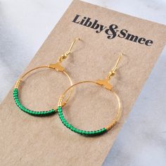 "Your soon-to-be favorites, these small gold beaded hoops (available in 16 exclusive patterns) are perfect for day, night and well, everything in between. + beaded hoops with tiny glass emerald green beads and gold glass Delica beads + gold-plated hoop and hooks (lead-free and nickel-free) + comes with plastic earring back for security + circle is approximately 1.25\" in diameter and overall length is about 2\" from top of hook + packaged on a hand-stamped kraft earring card in a clear resealing Adjustable Hoop Earrings With Gold Beads As Gift, Adjustable Gold Beads Hoop Earrings As Gift, Adjustable Gold Beaded Hoop Earrings As Gift, Small Hoop Earrings With Tiny Beads For Gift, Small Hoop Earrings With Tiny Beads As Gift, Gold Beads Hoop Earrings Gift, Gift Dangle Hoop Earrings With Gold Beads, Gold Beaded Dangle Hoop Earrings As Gift, Small Hoop Gold Beaded Earrings For Gifts