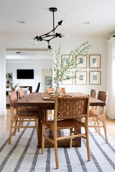 a dining room table with chairs and a rug on the floor