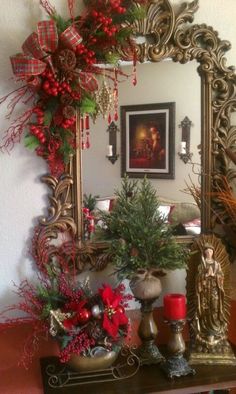 a mirror sitting on top of a wooden table next to a christmas tree and other decorations