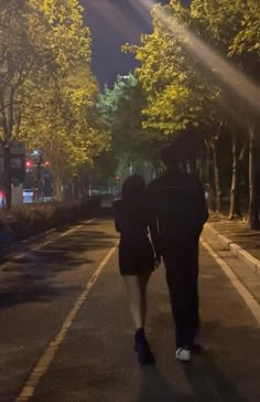 two people walking down the street at night