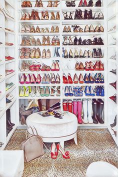 a shoe closet filled with lots of different colored shoes and purses on the floor