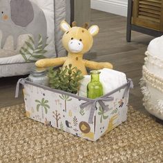 a stuffed giraffe sitting in a basket on the floor next to a baby crib