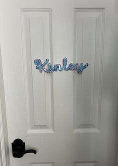 a white door with a black handle and some letters on the front door that say'kinley '