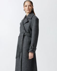 Women's long double-breasted coat made from yarn-dyed wool-blend twill cloth. The silhouette—which includes a lapel collar, long sleeves with cuff tab and matching-fabric waist belt—is inspired by the classic trench coat. Slanted side pockets and double-breasted button fastening. Timeless Outerwear With Belted Cuffs, Timeless Outerwear With Belted Cuffs For Fall, Timeless Fall Outerwear With Belted Cuffs, Office Wool Coat With Belted Cuffs For Fall, Belted Wool Pea Coat, Fitted Wool Coat With Belted Cuffs For Fall, Timeless Long Sleeve Outerwear With Belted Cuffs, Fall Wool Coat With Belted Cuffs For Office, Fall Office Wool Coat With Belted Cuffs