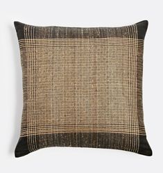 a brown and black plaid pillow on a white background