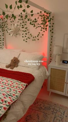 a teddy bear sitting on top of a bed in a room with white walls and plants