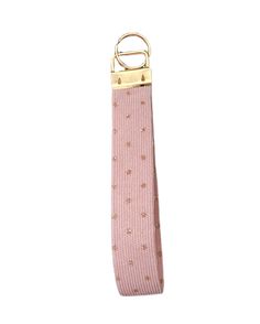 a pink tie with gold hardware hanging from it's end on a white background