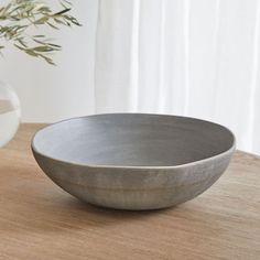 a gray bowl sitting on top of a wooden table