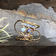 This collection was inspired by the unique ecosystems of the ocean and the significance of flora and fauna. Vastly different species rely on one another in order to thrive in their shared environment. Kyanite, aquamarine, tanzanite, ruby, labradorite, emerald, rose quartz and grossular garnet are all embedded in brass and come together in perfect harmony. This cuff is slightly adjustable and can be gently squeezed. Length 1 1/2" in Diameter 2 1/2" Cuff Opening 1" This piece is handmade-to-order, Garnet Stone Jewelry, Grossular Garnet, Life Aquatic, Funky Jewelry, Garnet Stone, Perfect Harmony, Wide Cuff, Ceramic Jewelry, Flora And Fauna