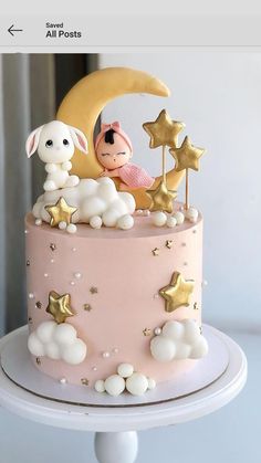 a pink cake with gold stars and a lamb on top