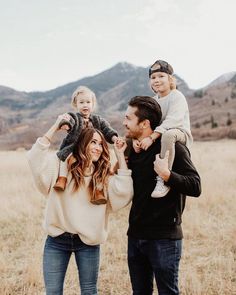 a man, woman and child standing in a field