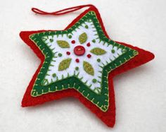 a red and green christmas ornament hanging on a white tablecloth covered surface