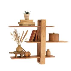 a wooden shelf with books, vases and other items on it in front of a white background