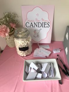 a table topped with lots of candy next to a sign and some jars filled with candies