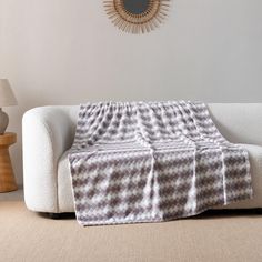 a living room with a white couch and a plaid blanket