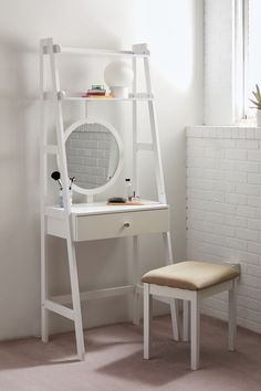 a white desk with a mirror, stool and shelf next to it in a room