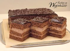 a cake with chocolate frosting is cut into slices and sits on a platter