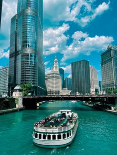 a boat is going down the river in front of some tall buildings and skyscrapers