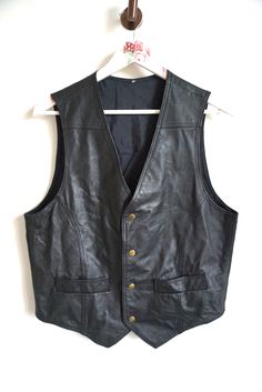 Vest details: * Black genuine leather vest * Button closure * 2 pockets * Condition: Perfect vintage condition Measurements: Length: 26" / 66 cm Armpit to armpit: 20 1/2" / 52 cm Shoulder to shoulder: 14" / 36 cm Label size: L Feel free to message me with any questions Black Leather Vest Casual, Black Leather Vest Vintage, Classy Jacket, Top Bikes, Mens Vests, Vest Outfits, Leather Vest, Label Sizes, Western Outfits