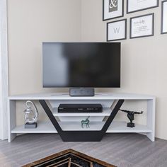 a flat screen tv sitting on top of a white shelf