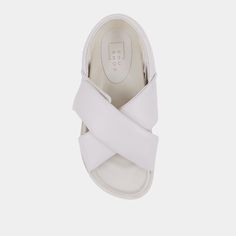 Introducing our DELTA flat sandal which boasts a modern and minimalist design, making it a timeless and classic option. This pair is crafted using super-soft faux leather and feature wide and cushioned crisscrossed upper straps that can be easily adjusted with the Velcro feature. With molded footbeds, these slides provide ultimate comfort and sophistication, making them an excellent choice for warm weather dressing. You can pair them with anything from skirts to midi dresses to complete your spr Modern Slides With Removable Insole For Everyday, White Flat Everyday Sandals, White Flat Sandals For Everyday, White Flat Sandals For Everyday Wear, Modern Everyday Slingback Sandals For Summer, Everyday Flat Synthetic Sandals, White Leather Cross Strap Sandals, Modern Double Strap Footbed Sandals For Spring, White Leather Sandals For Everyday