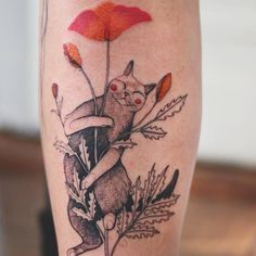 a tattoo on the leg of a woman with flowers and a cat holding an umbrella