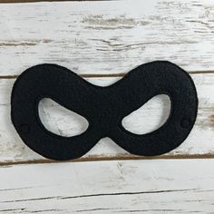 a black mask on top of a wooden table