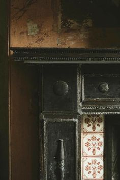 an old black cabinet with drawers and knobs