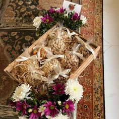 two baskets filled with flowers and nuts on top of a rug