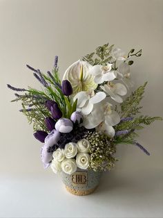 a vase filled with white and purple flowers