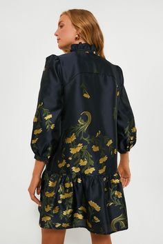 A feminine silhouette filled with movement and grace, the Navy Jasmine Vine Palmerston Dress is the dress of our dreams. A ruffled collar and long sleeves play for a sophisticated feel while the golden florals are perfect for year-round styling. Pair with heels and gold earrings for an upcoming trip, shower, or brunch! Standup ruffle collar Notched neckline Three-quarter length sleeves Drop waist Mini length A-line silhouette Lined Jacquard fabric Material: 100% Polyester (outer), 97% Polyester, Fitted Dress With Ruffled Collar For Fall, Fitted Fall Dresses With Ruffled Collar, Long Sleeve Jacquard Evening Dresses, Elegant Jacquard Dresses For Fall, Elegant Fall Dresses With Ruffled Collar, Formal Long Sleeve Ruffle Dress For Fall, Formal Long Sleeve Dress With Ruffles For Fall, Chic Fall Dresses With Ruffled Collar, Formal Long Sleeve Jacquard Dress