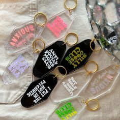 six keychains with different designs on them sitting next to each other in front of a mirror