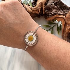 a woman's arm with a bracelet and a flower in the center on it