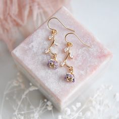 "Light Purple Flower Earrings // Gold Filled Earrings // Boho Bridal Earrings // Floral Earrings // February Birthstone // Birth Flower // Wild Flower Earrings // Birthday Gift // Gift for Mom :: Provide an enchanting effect with these fresh floral earrings :: These light purple flower earrings are a delicate and feminine design perfect for any boho wedding attire or for adding a little sparkle to your next special occasion. The tiny purple flower petals are created with faceted glass and secured to golden stems featuring small cubic zirconia leaves. The wild flower earrings are light weight and suspended from comfortable 14k gold filled earrings. Whether adding these flower earrings for a lovely touch of color and sophistication to your wedding day these will arrive suitably gift wrapped Delicate Teardrop Flower Earrings For Pierced Ears, Delicate Teardrop Flower Earrings, Lavender Pierced Earrings For Gift, Lavender Dangle Earrings For Wedding, Lavender Flower-shaped Earrings For Gifts, Elegant Lavender Earrings With Ear Wire, Elegant Lavender Flower Earrings For Gift, Delicate Pierced Flower Drop Earrings, Delicate Round Earrings With Flower Charm