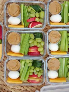 several plastic containers filled with different types of vegetables and dips on top of each other