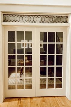 an empty room with white doors and wood flooring in front of the sliding glass door