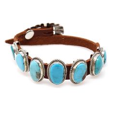 "This Navajo bracelet, created by Danny Martinez, features seven unique turquoise stones and a sterling silver buckle fastened to a brown leather band. Each stone differs in size, for reference the center stone & setting is 7/8"" x 1/2"", and is set in sterling silver. Each bracelet is distinctive since the stone and shell characteristics can vary from one bracelet to the next. Due to the adjustable buckle, this bracelet can fit a wrist up to 9"" in circumference depending on your personal prefe Adjustable Turquoise Western Bracelet, Adjustable Turquoise Leather Bracelet With Concho, Adjustable Turquoise Leather Bracelet Southwestern Style, Turquoise Leather Concho Bracelets, Adjustable Turquoise Leather Bracelet In Southwestern Style, Southwestern Silver Leather Jewelry, Western Leather Jewelry With Concho, Western Style Turquoise Leather Bracelets, Southwestern Turquoise Leather Jewelry