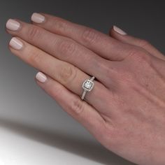 a woman's hand with a diamond ring on it