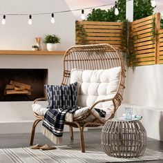 a wicker chair sitting in front of a fire place next to a white rug