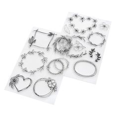 several different types of metal jewelry on a white surface with one being cut out and the other is drawn