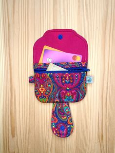 a colorful purse with a tie hanging from it's side on a wooden surface