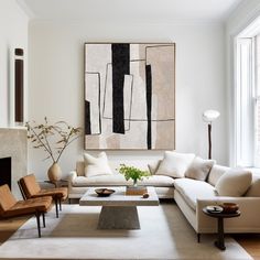 a living room filled with furniture and a painting hanging on the wall above it's fireplace