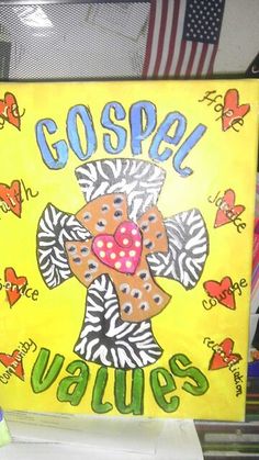 a cross painted on a yellow canvas with hearts and the words gospa jesus