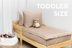 there is a small bed with a teddy bear on it and the words toddler size above it