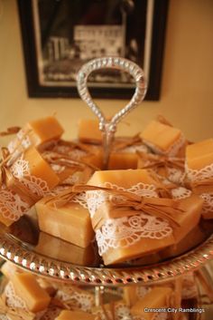 several pieces of soap sitting on a glass platter with lace and bow tie around the edge