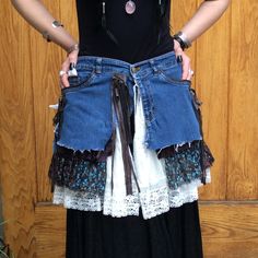 "Handmade Repurposed Wrap Skirt Perfect for summer festivals A combination of mixed textiles including denim, floral print fabric, lace, and brown fringe. No visible signs of wear and tear. Measurements (taken laying flat on front side): Waiste: 31\" Length from waiste: 17 1/2\" Send us a message with any questions! JMM" Bohemian Fitted Skirt With Frayed Hem, Bohemian Bottoms With Frayed Hem For Festivals, Bohemian Festival Bottoms With Frayed Hem, Bohemian Denim Skirt With Patchwork Details, Bohemian Denim Skirt With Patchwork, Bohemian Cotton Skirt With Frayed Hem, Cotton Skirt With Lace Trim For Festival, Festival Skirt With Lace Trim, Upcycled Bohemian Bottoms For Spring