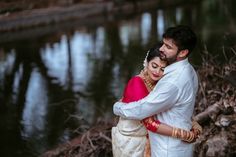 a man and woman standing next to each other near water